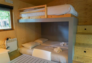 Interior view of Forest Lodge cabin at Het Amsterdamse Bos, showing bunk beds and wooden decor.