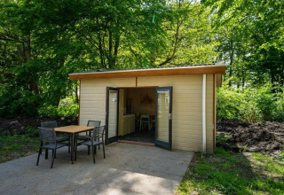 Acogedora cabaña Forest Lodge con terraza y asientos al aire libre en Het Amsterdamse Bos, Países Bajos.