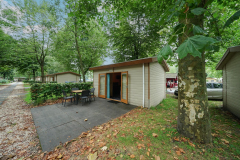 Cabaña Forest Lodge en Het Amsterdamse Bos, Países Bajos, con terraza y entorno de árboles verdes.