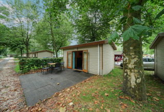 Cabaña Forest Lodge en Het Amsterdamse Bos, Países Bajos, con terraza y entorno de árboles verdes.