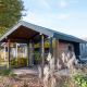 Moderne Tiny House Lodge bei De Wije Werelt in den Niederlanden, umgeben von Natur und Pflanzen.