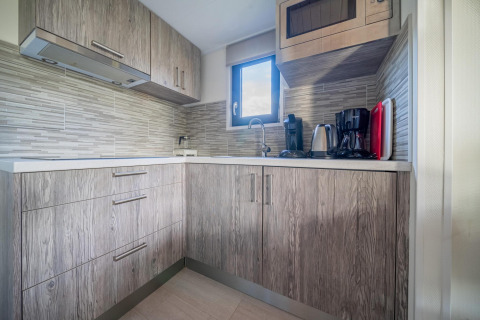 Moderne Küchenzeile im Tiny House bei De Wije Werelt, Niederlande, mit Kaffeemaschine und Wasserkocher.