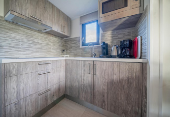 Moderne tekøkken i Tiny House på De Wije Werelt, Holland, udstyret med kaffemaskine og elkedel.