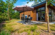 Buitenzitplaats bij Pavilion lodge op De Wije Werelt in Nederland, mensen zitten onder een grote parasol.