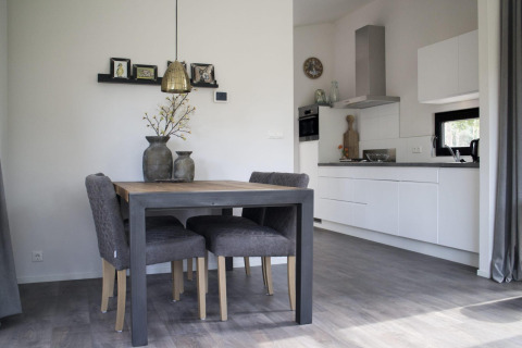 Sala da pranzo e cucina moderne al Pavilion presso De Wije Werelt lodge nei Paesi Bassi con sedie grigie.