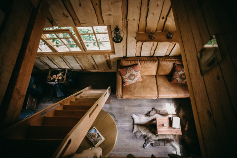 Gemütliches Tiny House Tree House bei Cosy Cabins im Wald von Limburg, Belgien, mit Holzinterieur.