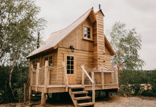 Cabaña de madera Tree House 1 en Cosy Cabins en el bosque de Limburg, Bélgica, con un diseño acogedor.