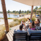 Gezin ontspant op het terras van de Beach lodge | Port bij Vakantiepark Leukermeer, Nederland.