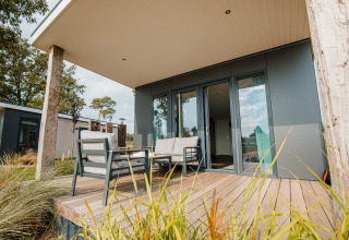 Terraza de una moderna beach lodge con asientos exteriores en Vakantiepark Leukermeer, Países Bajos.
