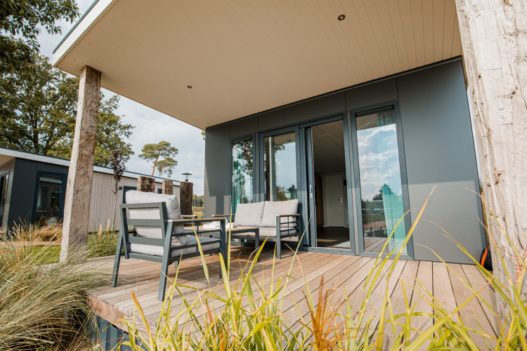 Moderne Beach Lodge mit Terrasse und Sitzgelegenheiten im Vakantiepark Leukermeer in den Niederlanden.