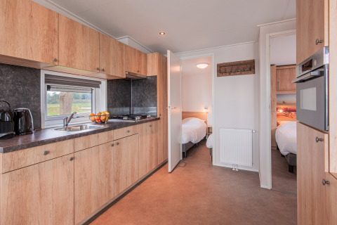 Modern kitchen and two bedrooms in a beach lodge at Vakantiepark Leukermeer in the Netherlands.