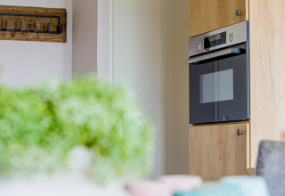 Horno empotrado moderno con acabado de madera en Beach Lodge en Vakantiepark Leukermeer, Países Bajos.