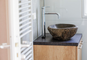 Bagno moderno con lavabo in pietra naturale e rubinetto cromato al Beach lodge | Port, Vakantiepark Leukermeer, Paesi Bassi.