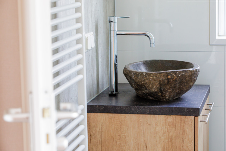 Modernes Badezimmer mit Natursteinwaschbecken und Chromarmatur im Beach lodge | Port, Vakantiepark Leukermeer.