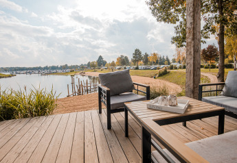 Beach lodge | Port at Vakantiepark Leukermeer in the Netherlands with terrace seating and lakeside view.