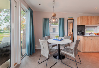 Heller Essbereich mit rundem Tisch und vier Stühlen in der Beach Lodge im Vakantiepark Leukermeer, Niederlande.