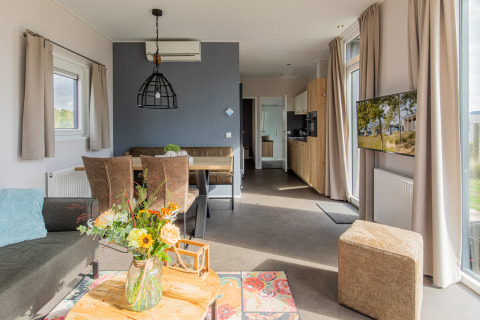 Moderne leefruimte in Beach lodge | Island te Vakantiepark Leukermeer, Nederland, met grote ramen.