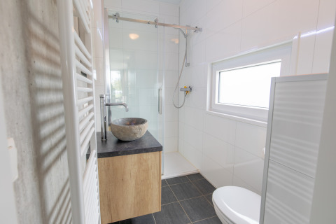 Salle de bain moderne et compacte à Beach lodge, Vakantiepark Leukermeer, Pays-Bas, douche et vasque en pierre.
