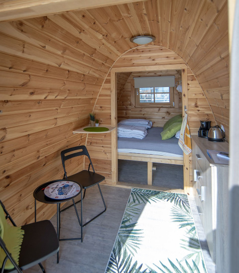Vue intérieure de la tiny house Water Bubbles à Marina Parcs Almere, Pays-Bas, avec déco chaleureuse.