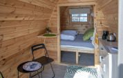 Vista interna della tiny house Water Bubbles a Marina Parcs Almere, Paesi Bassi, con arredo accogliente.