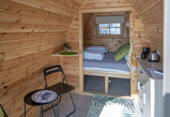 Vista interna della tiny house Water Bubbles a Marina Parcs Almere, Paesi Bassi, con arredo accogliente.