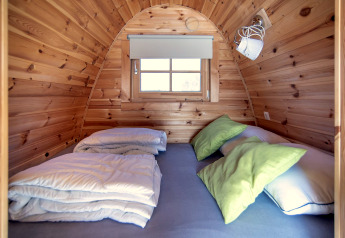 Cozy tiny house at Water bubbles, Marina Parcs Almere, Netherlands, featuring bed and wooden walls.