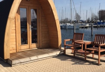 Kleines Holzhaus namens Water bubbles im Marina Parcs Almere mit Blick auf Boote, Niederlande.