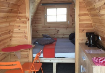 Interior of a tiny house called Water bubbles at Marina Parcs Almere, Netherlands, with wood walls.