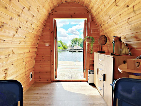 Vista interior de una tiny house llamada Water Bubbles en Marina Parcs Almere, Países Bajos, frente al agua.