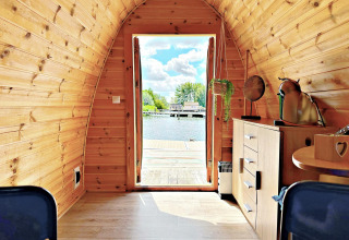 Interior view of a tiny house called Water Bubbles at Marina Parcs Almere, Netherlands, facing the water.