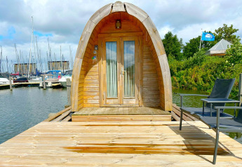 Tiny house chiamata Water Bubbles al Marina Parcs Almere, Paesi Bassi, su un molo di legno sull’acqua.