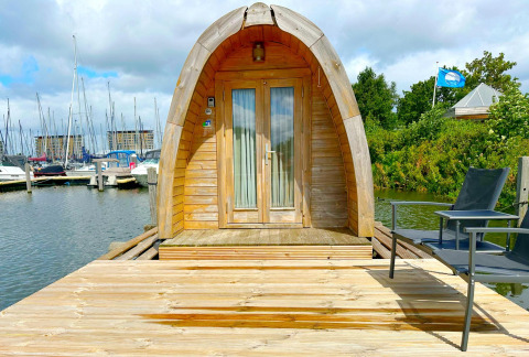 Tiny house chiamata Water Bubbles al Marina Parcs Almere, Paesi Bassi, su un molo di legno sull’acqua.