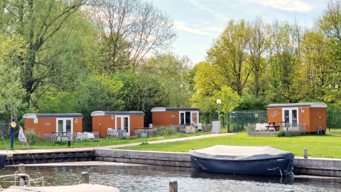 Tiny Wagons bei Marina Parcs Naarden in den Niederlanden mit Wasser und grüner Umgebung.