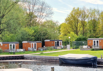 Tiny wagons a Marina Parcs Naarden, nei Paesi Bassi, circondati dal verde e da un piccolo porto.