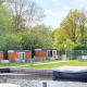 Tiny wagons bij Marina Parcs Naarden in Nederland, temidden van groen met een haventje vooraan.