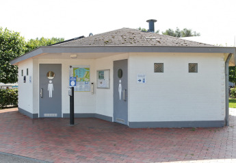 Baños públicos en Tiny wagons, Marina Parcs Naarden, Países Bajos, con puertas individuales para mujeres y hombres.