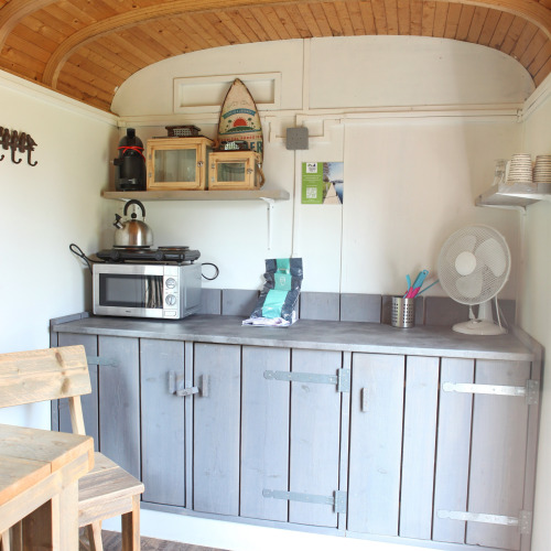 Kleine Küchenzeile in einem Tiny House bei Marina Parcs Naarden, Niederlande, mit Holzdach und Schränken.