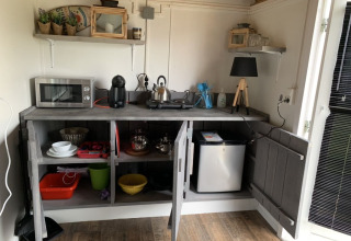 Compacte kitchenette in een Tiny wagons bij Marina Parcs Naarden, Nederland, met zichtbare apparaten.