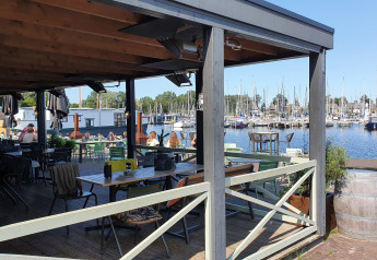 Udsigt over en marina fra en udendørs restaurant ved Tiny wagons på Marina Parcs Naarden, Holland.
