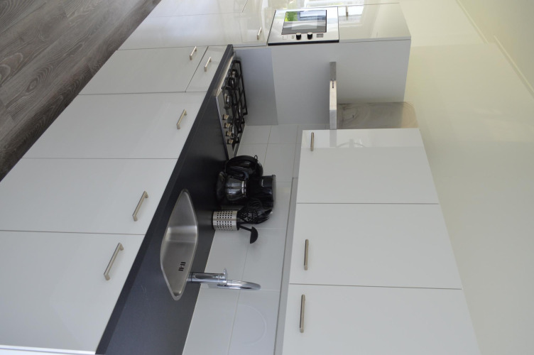 Cocina moderna con armarios blancos, encimera negra, fregadero, estufa y electrodomésticos en un lodge.