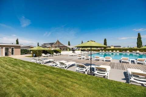 Buitenzwembad met ligstoelen en groene parasols aan Biebosch - Sunshower, Resort Mooi Bemelen, Nederland.
