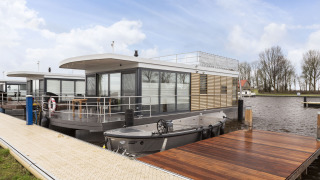 Houseboat moderno con terrazza sul tetto ormeggiato a Offingawier, Frisia, nei Paesi Bassi.