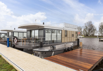 Modern houseboat with roof terrace docked at a marina in Offingawier, Friesland, Netherlands.