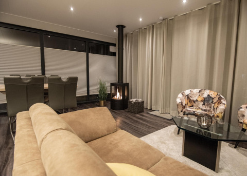 Salón moderno en una casa flotante con asientos cómodos, chimenea y comedor en Offingawier, Países Bajos.