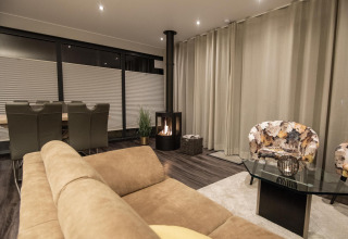 Salón moderno en una casa flotante con asientos cómodos, chimenea y comedor en Offingawier, Países Bajos.