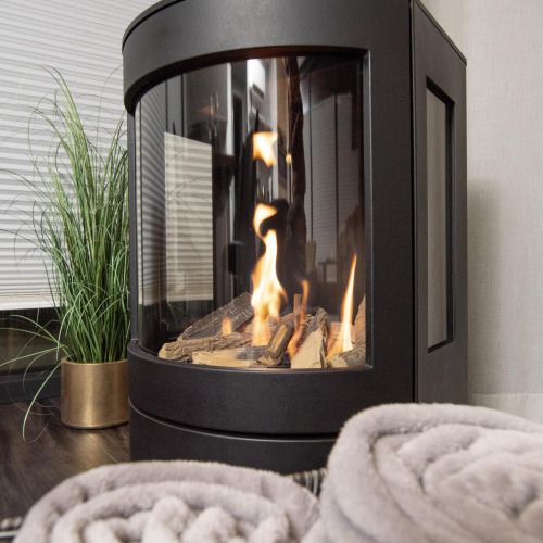 Chimenea moderna con leños y llamas, mantas acogedoras y planta en una casa flotante en Offingawier.