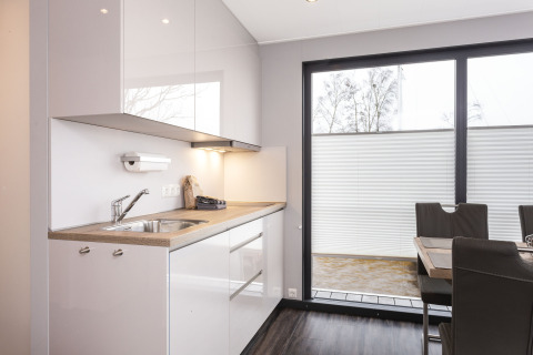 Cocina moderna y comedor en una casa flotante con ventanales en Welcome In - Friesland, Países Bajos.