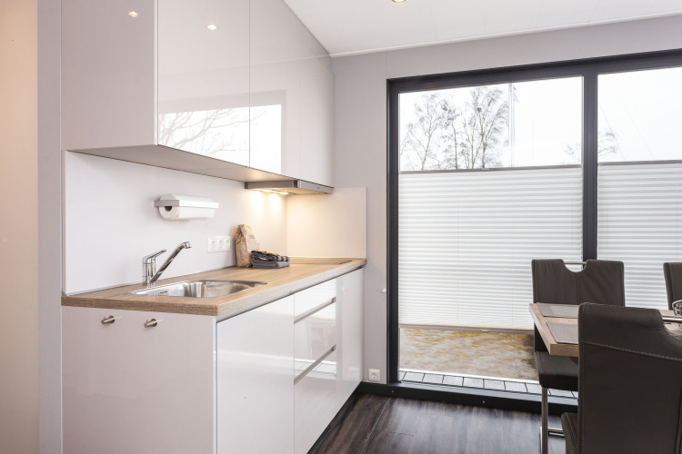 Cocina moderna y comedor en una casa flotante con ventanales en Welcome In - Friesland, Países Bajos.