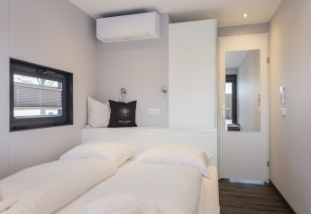 Lichte slaapkamer op woonboot in Offingawier, Nederland, met tweepersoonsbed en moderne inrichting.