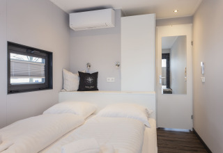 Modernes Schlafzimmer auf einem Hausboot in Offingawier, Niederlande, mit Doppelbett und schlichter Einrichtung.